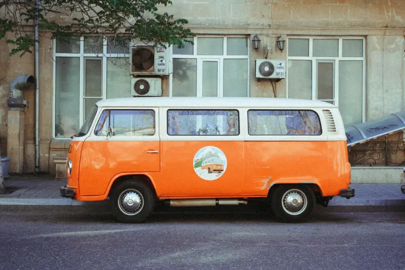 Retro orange van parked on an urban street with vintage flair, reflecting nostalgia