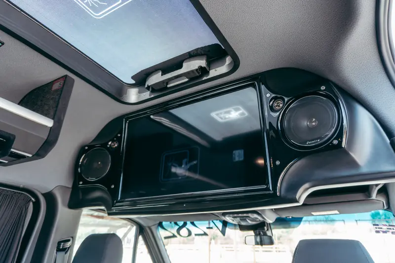 Interior of a luxury van featuring a built-in entertainment system and speakers