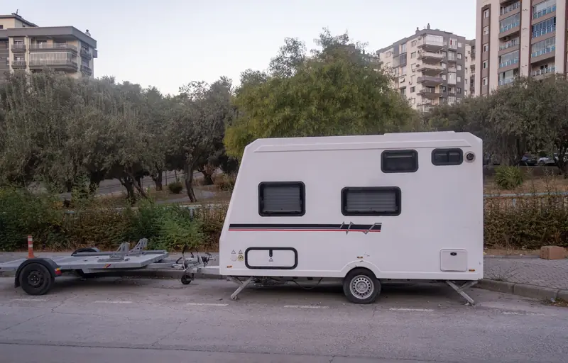 A sleek white camper van parked in an urban area in İzmir, Türkiye